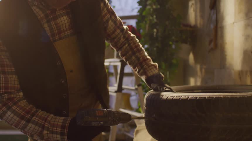 Man puncturing a tire with a screwdriver