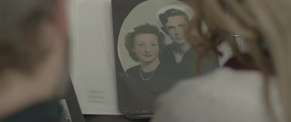 Person looks at an old photograph of a man and woman