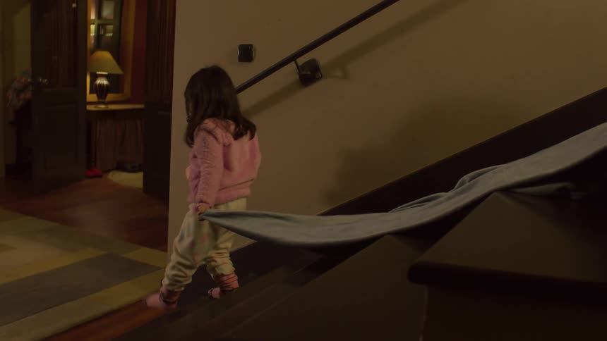 Little girl dragging her blanket walking down stairs then running across the room