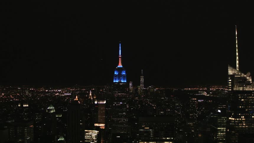 The buildings of nyc are lit at night