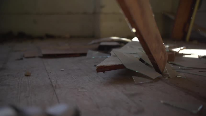 Woodlands in a room and breaks a piece of glass