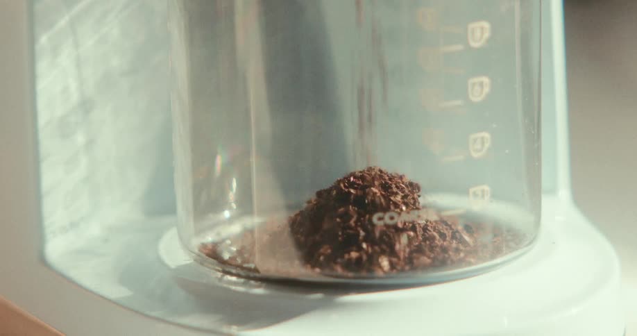 Coffee grounds are being poured into a coffee maker