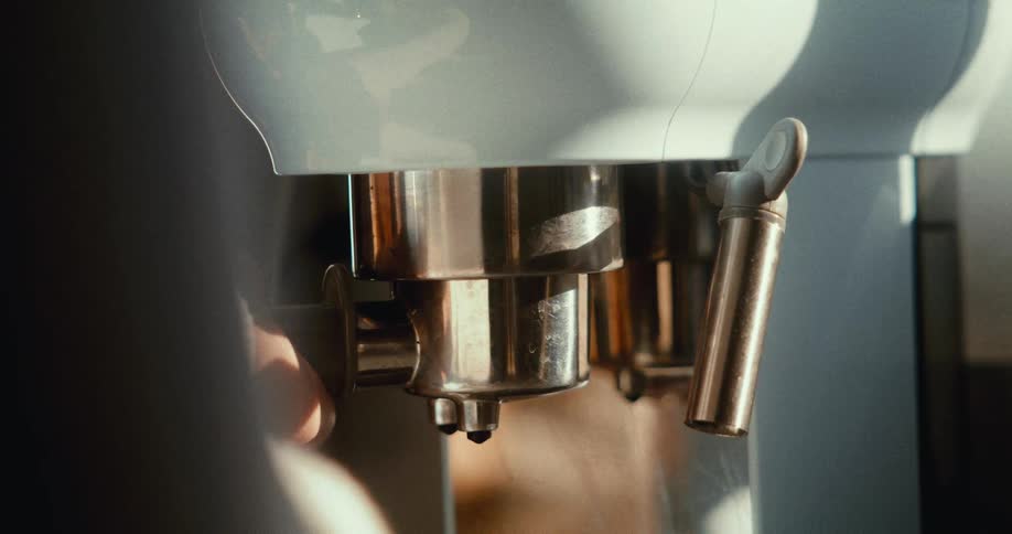 A closeup of an espresso machine with a portafilter filled with ground coffee ready to brew