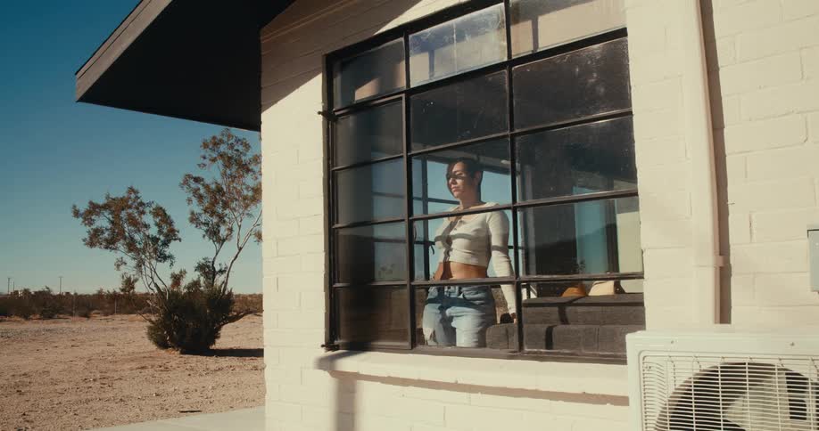 Woman opening a window curtain