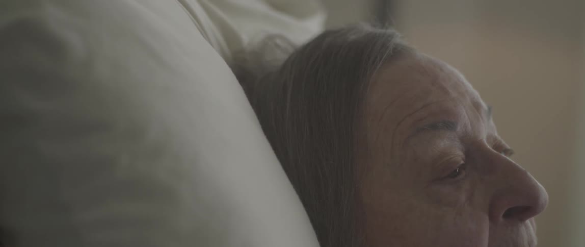 Elderly woman lies in bed