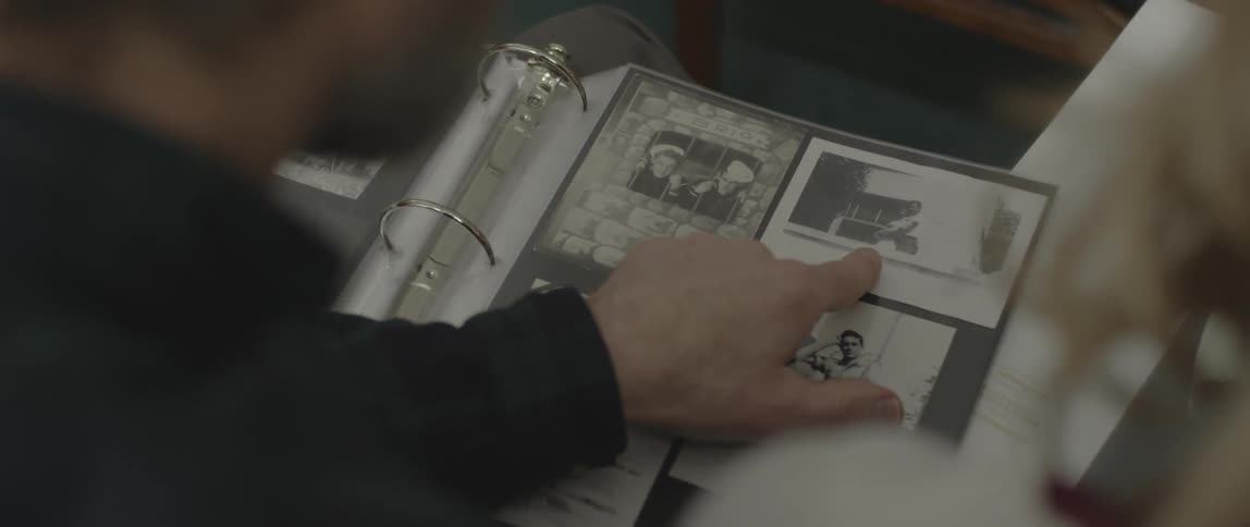 Two people sit and browse through photo albums