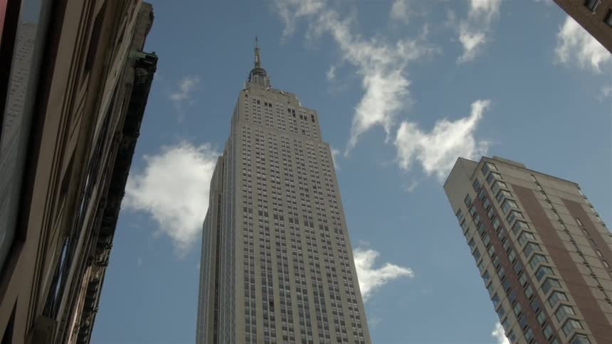 City skyscrapers tower overhead as clouds pass by