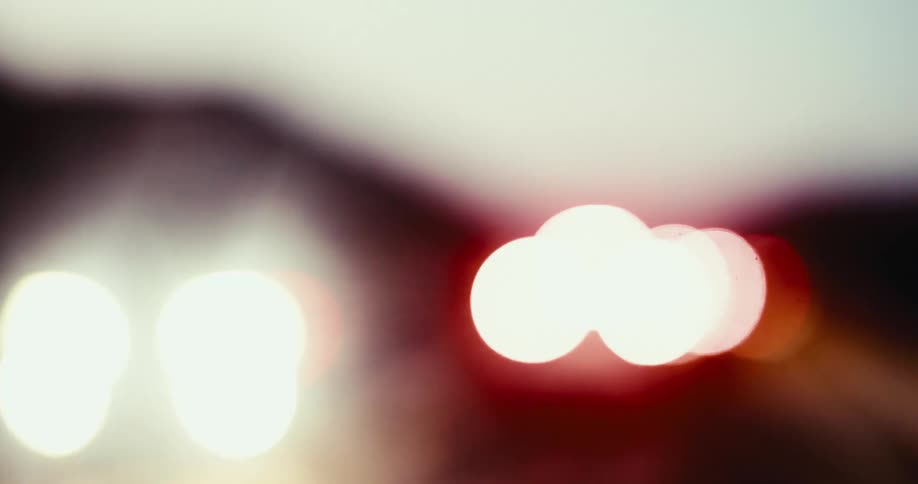 The tail lights of cars that are all blurred in motion