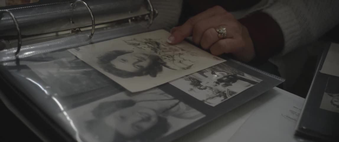 A woman looks at a photo album