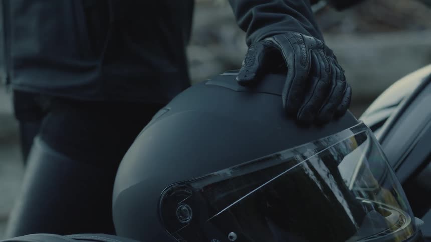 A footage of a persons body touching an helmet