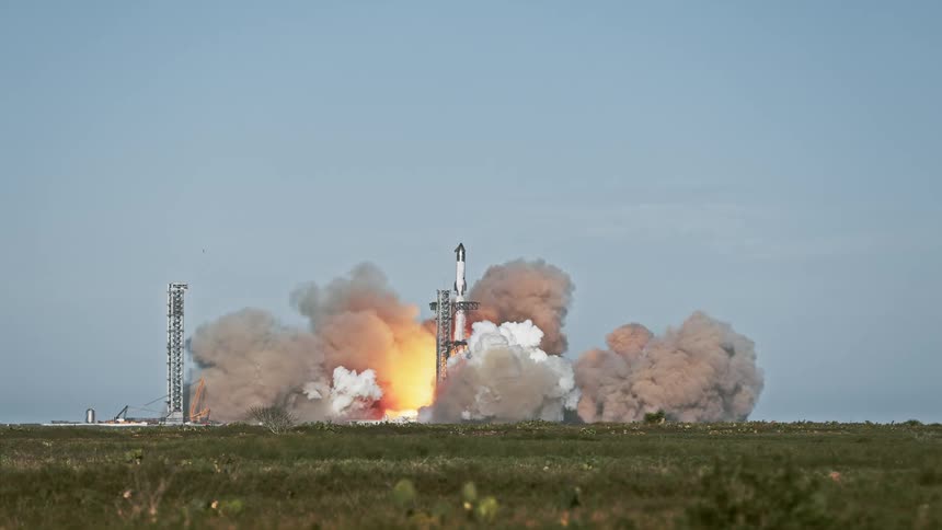 A rocket is launching into the sky surrounded by bright flames and thick clouds of smoke as it lifts off from the launch pad