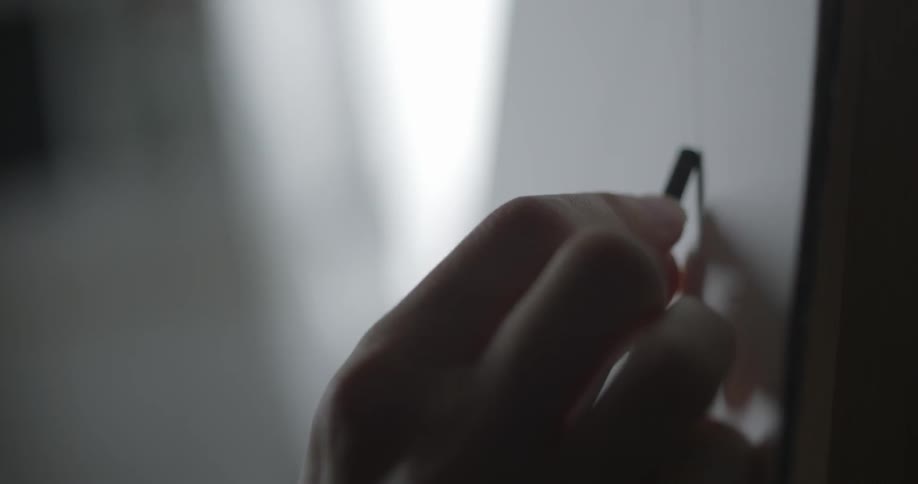A person draws with a charcoal pencil
