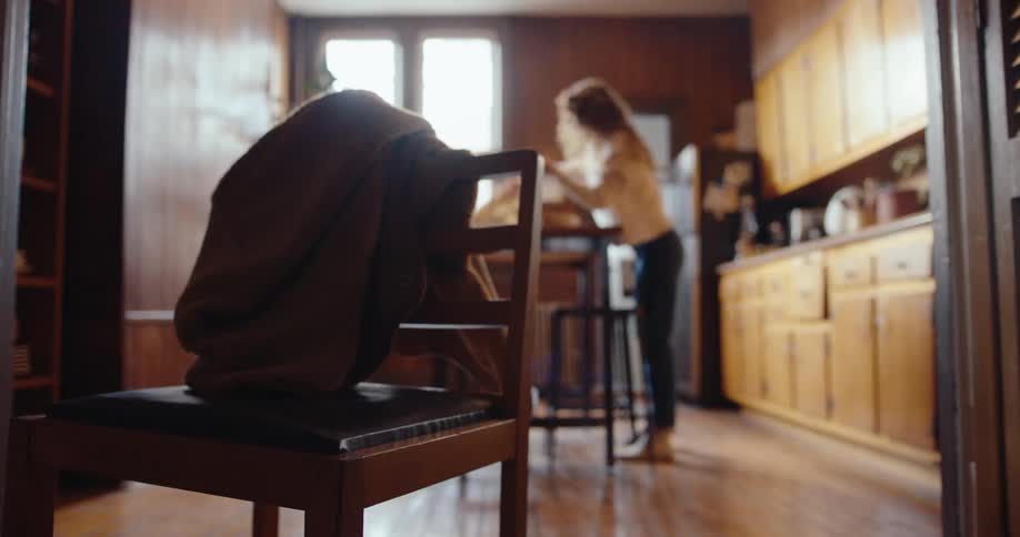 A young woman is running around the house hurriedly getting ready to go out