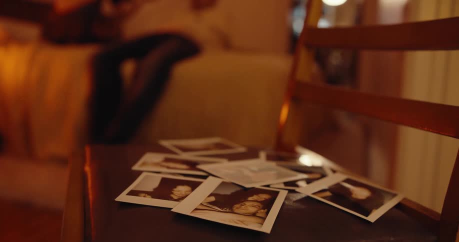 A clip of a person dropping a picture on a wooden furniture