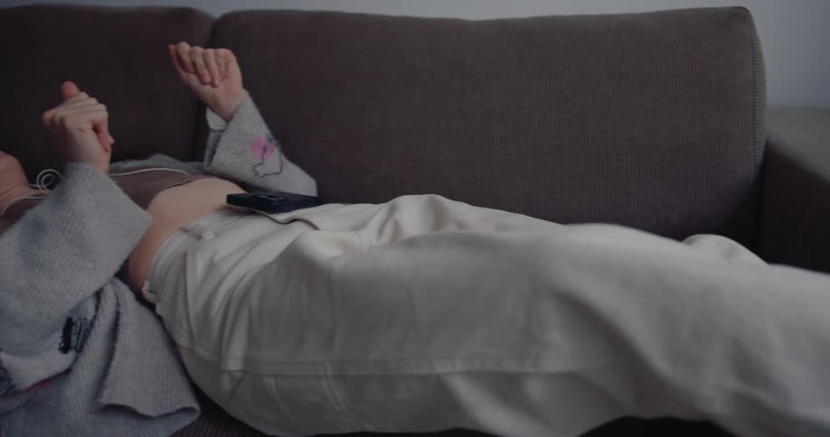 A woman is listening to music on the couch
