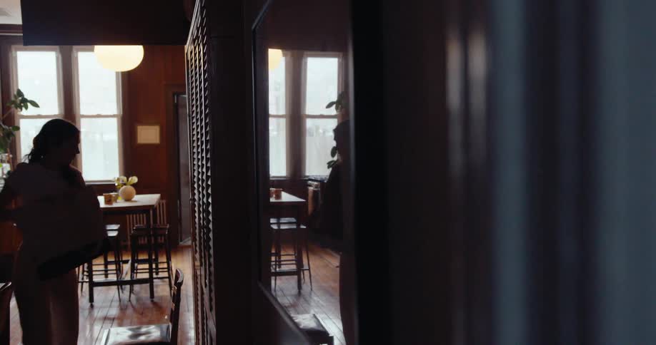 Woman climbing on a chair to get objects from a cupboard