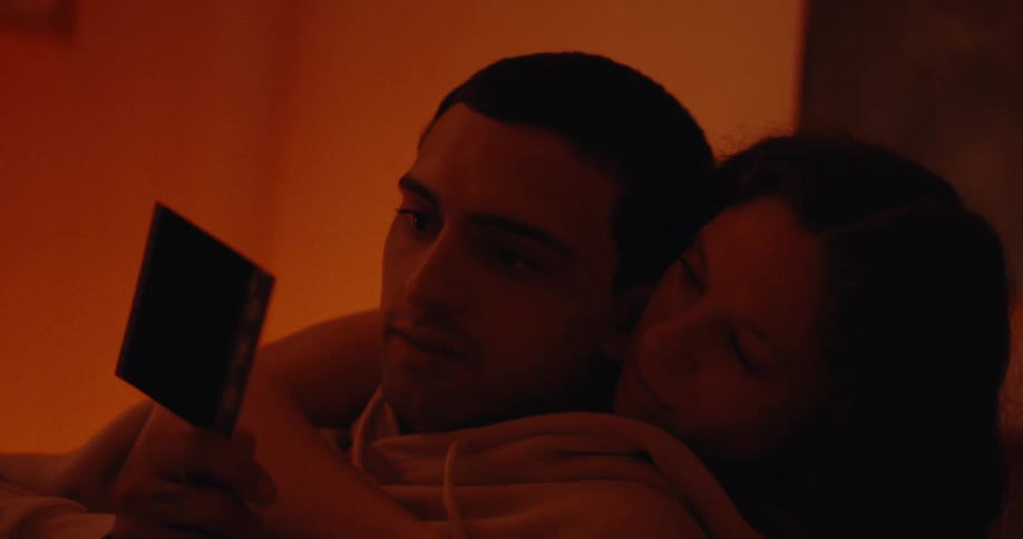 A clip of a man and a woman having a conversation while looking at pictures