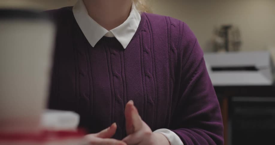 Woman sitting at table tapping her fingers impatiently
