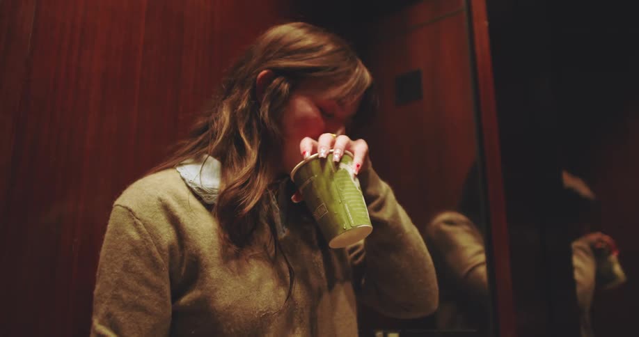 Happy woman taking a deep breath while inside an elevator
