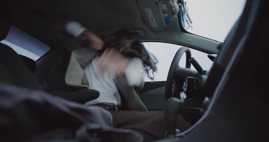 Man eating and dancing wildly inside the car