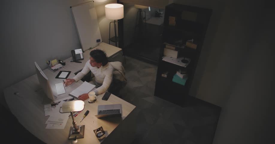 Man writing in front of a computer in an office room