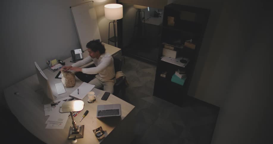 Man getting up from his chair and grabbing a snack while in an office environment