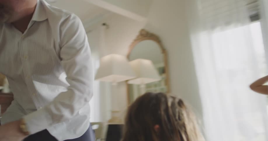 Father taking care of three children who are playing in a room
