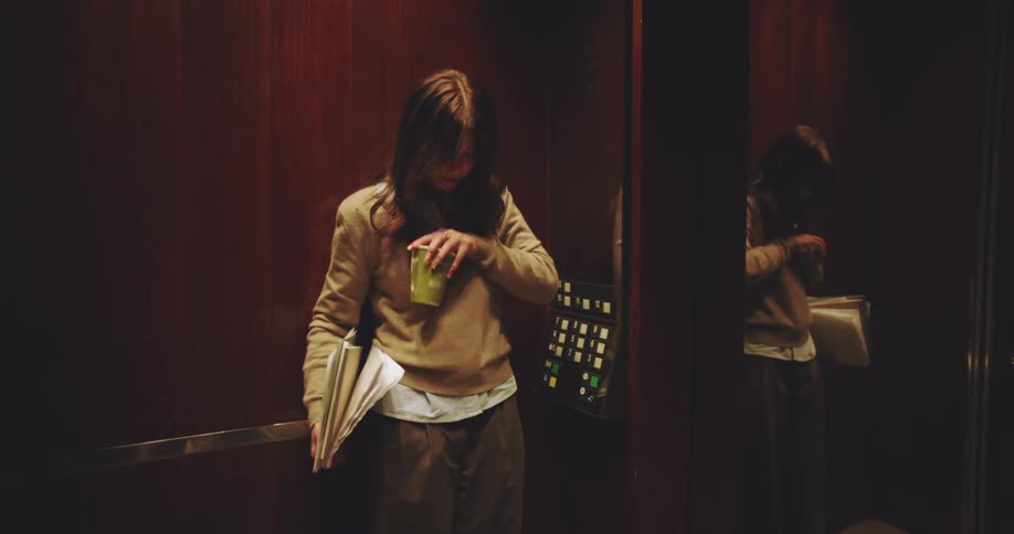 Woman entering an elevator and spilling drink