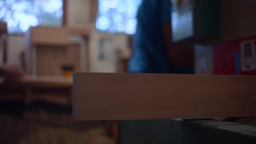 Carpenter placing wooden parts in a machine