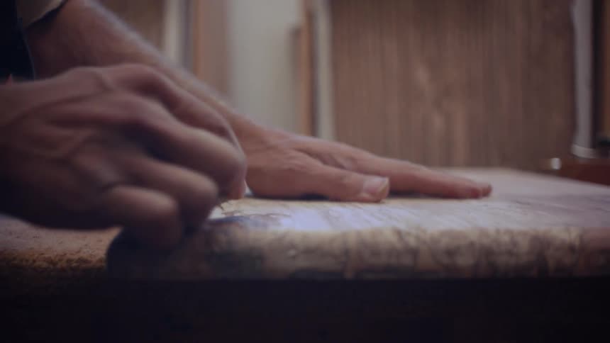 Carpenter sanding a piece of wood