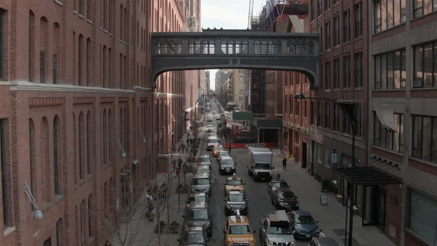 A city filled with cars that are traveling and people are walking