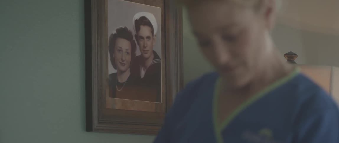 A woman is standing in a room with a portrait on the wall