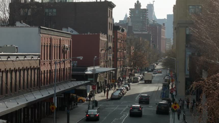 Cars traveling and people walking down a city street