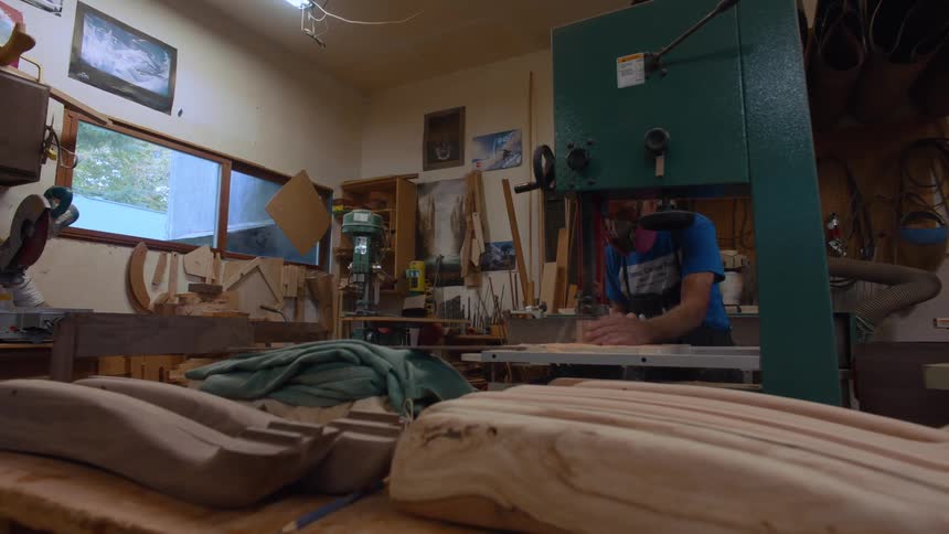 Carpenter in mask working in a workshop on a machine