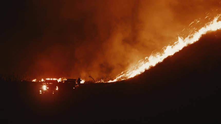 Silhouette of a mountain on fire at night