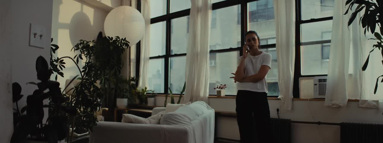 Woman walking in living room and talking on cell phone