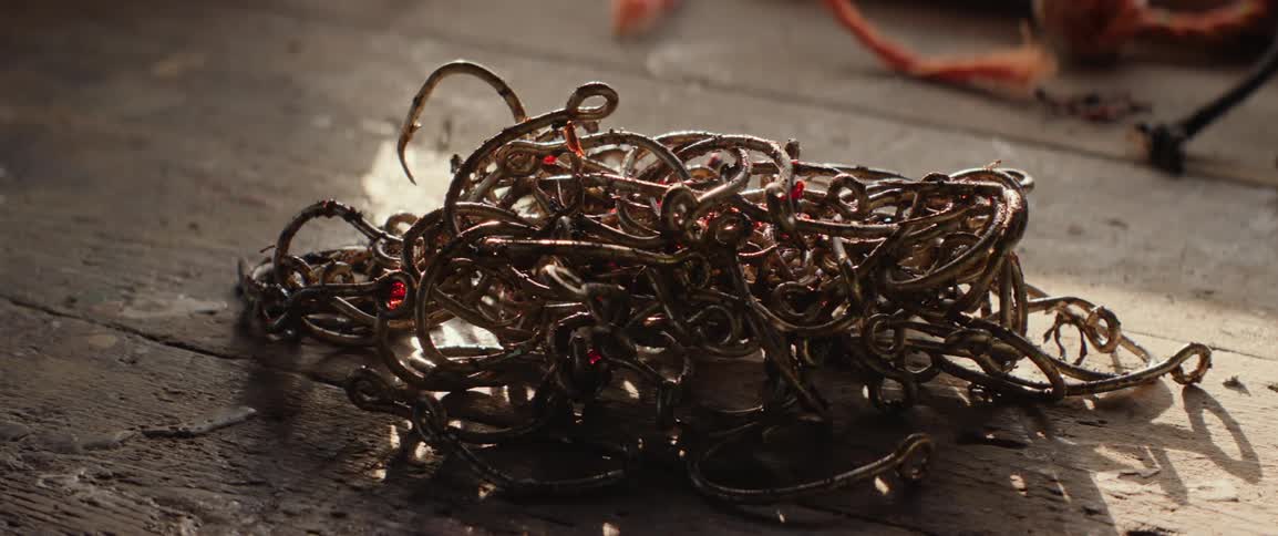 A clip of metal fishing hooks on the wooden bench