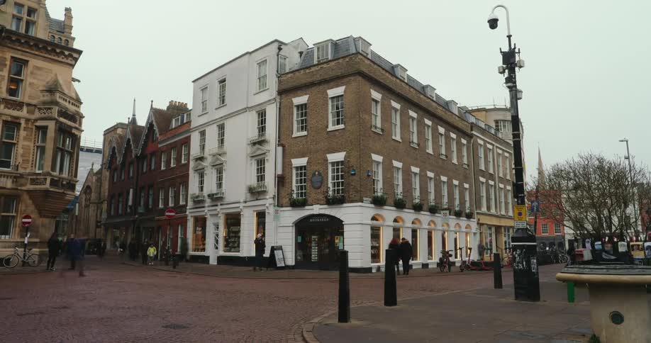 Pedestrians walking through a square in a city with classical architecture