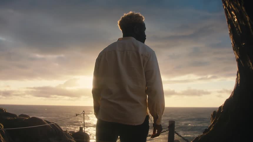 A footage of a man standing by the shore