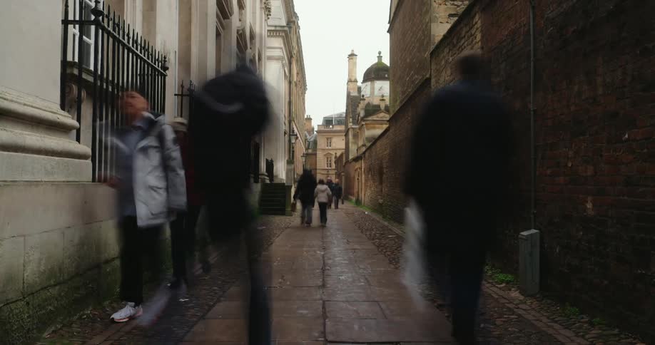 Pedestrians walking along a corridor lined with classical buildings
