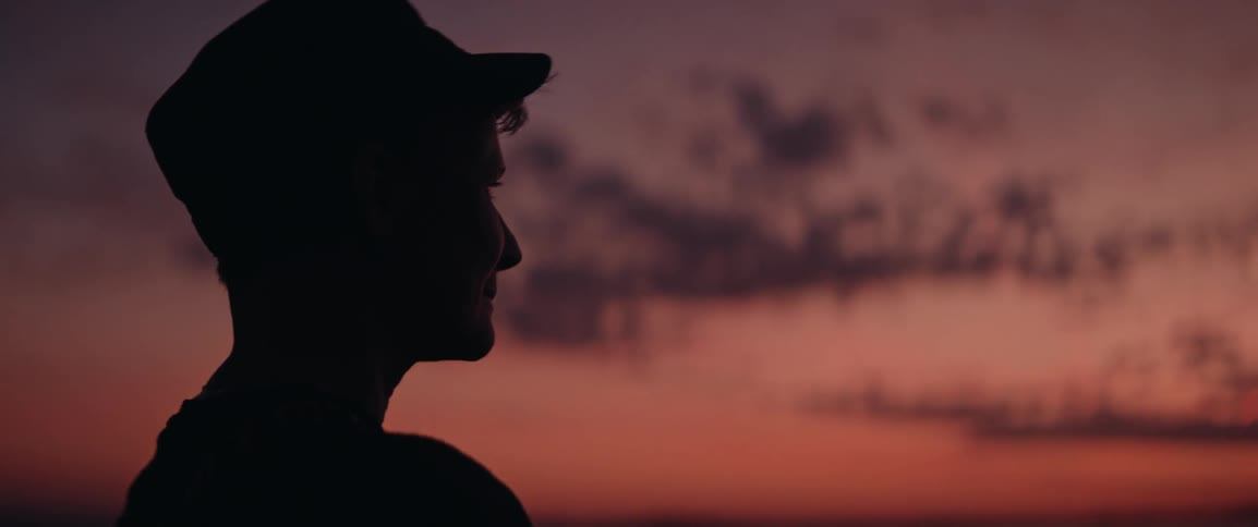 Silhouette of a person wearing a cap enjoying the view of a red sunset