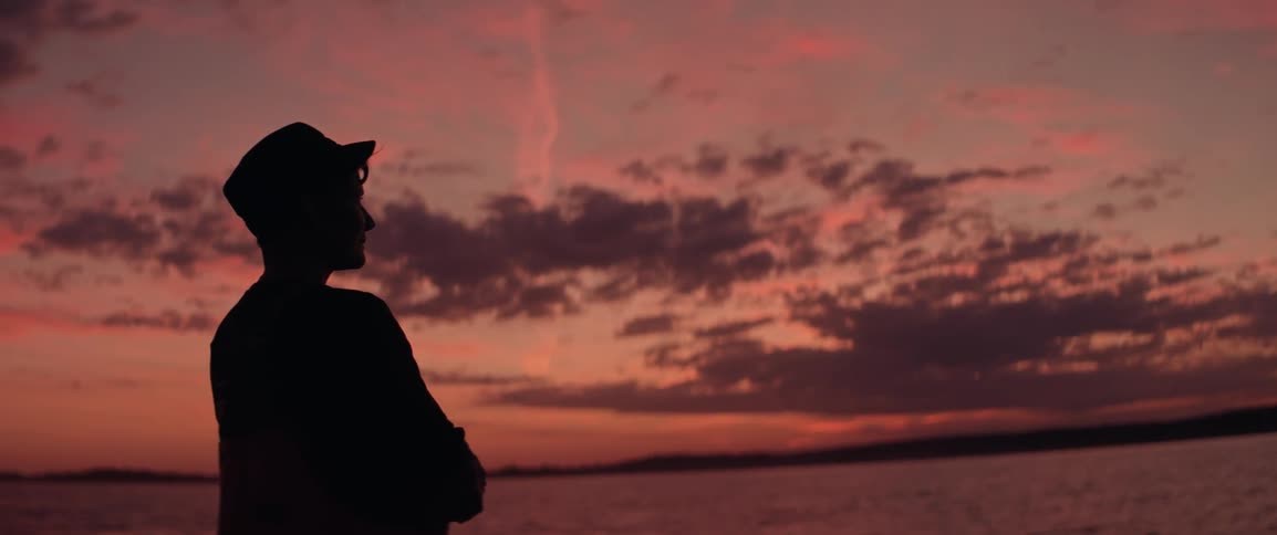 Female silhouette watching the sunset across the ocean