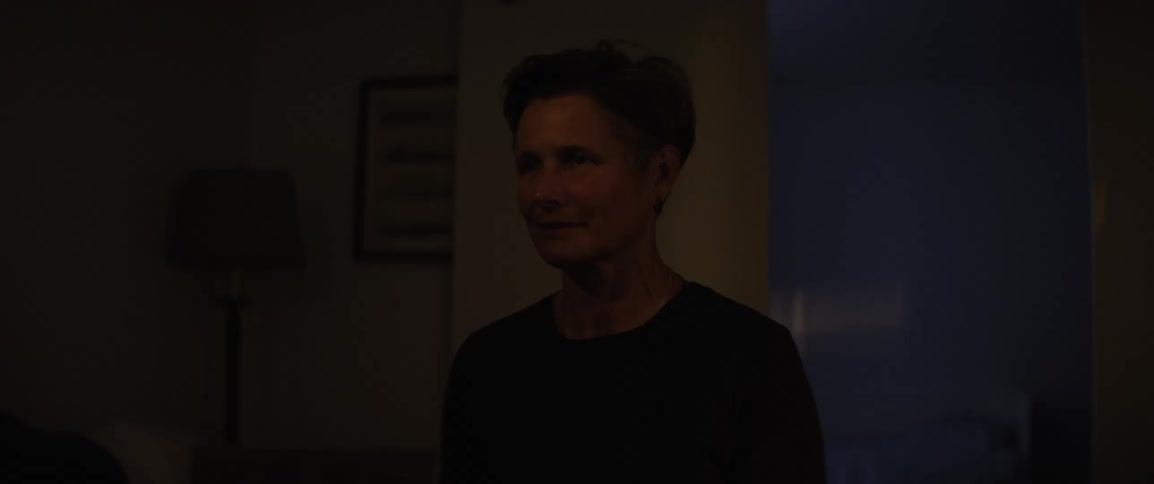 Person sitting in a room with a beam of light passing across their face