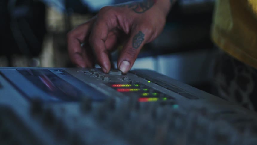 A musician is pressing buttons on the sound board