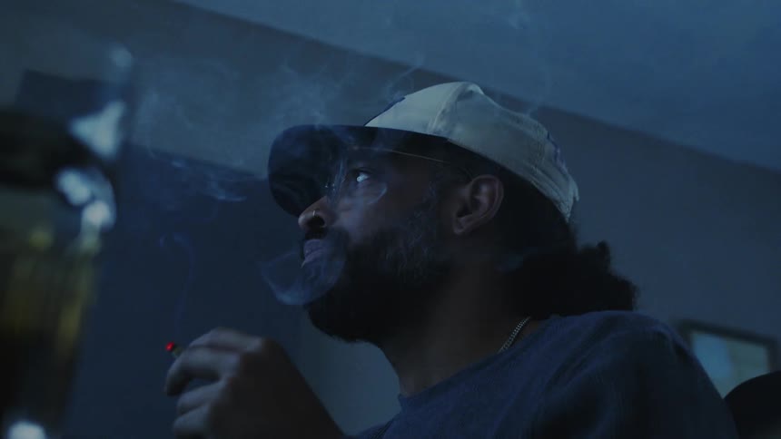 A man is smoking while listening to music