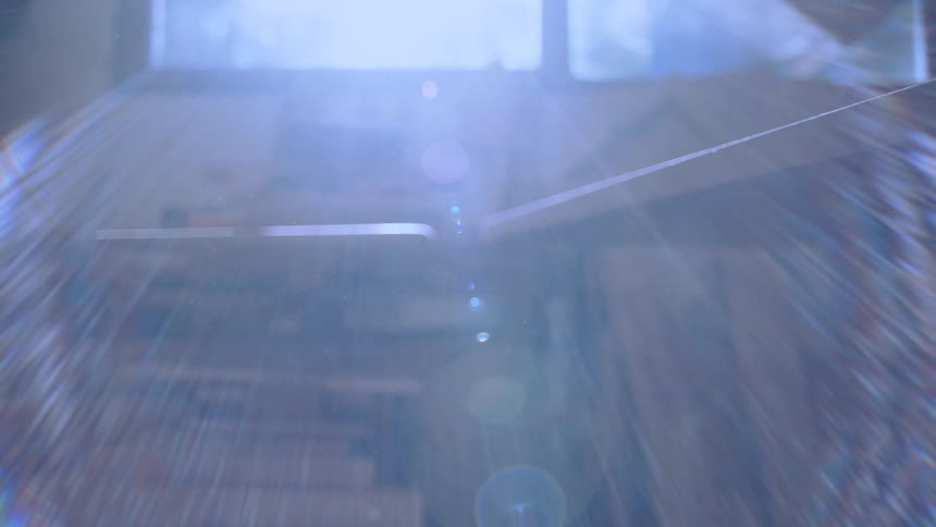 Bright sunlight streams into the workshop from under a workbench as the camera moves forward then back