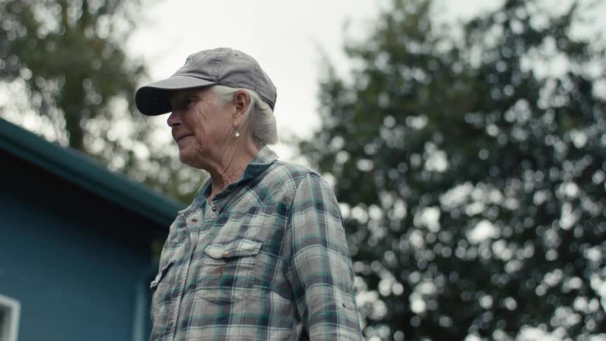 Elderly lady with happy facial expression in a backyard