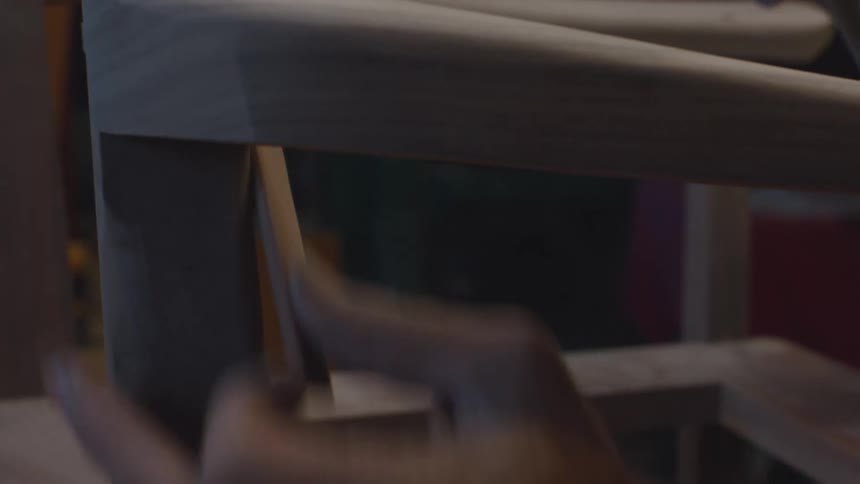 Pair of hands sanding a wooden chair