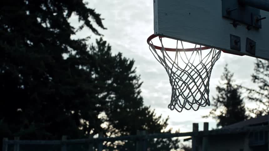 A basketball hoop with a white net in an outdoor with white sky