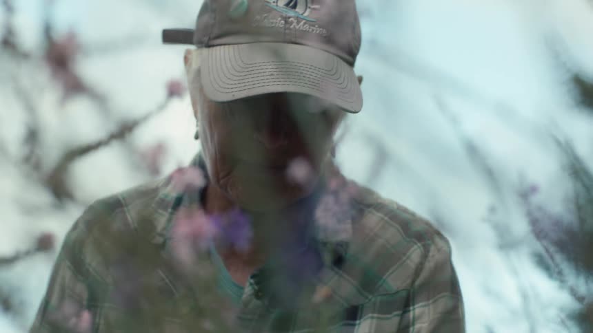 Closeup of an elderly woman tending to a garden of lavender flowers